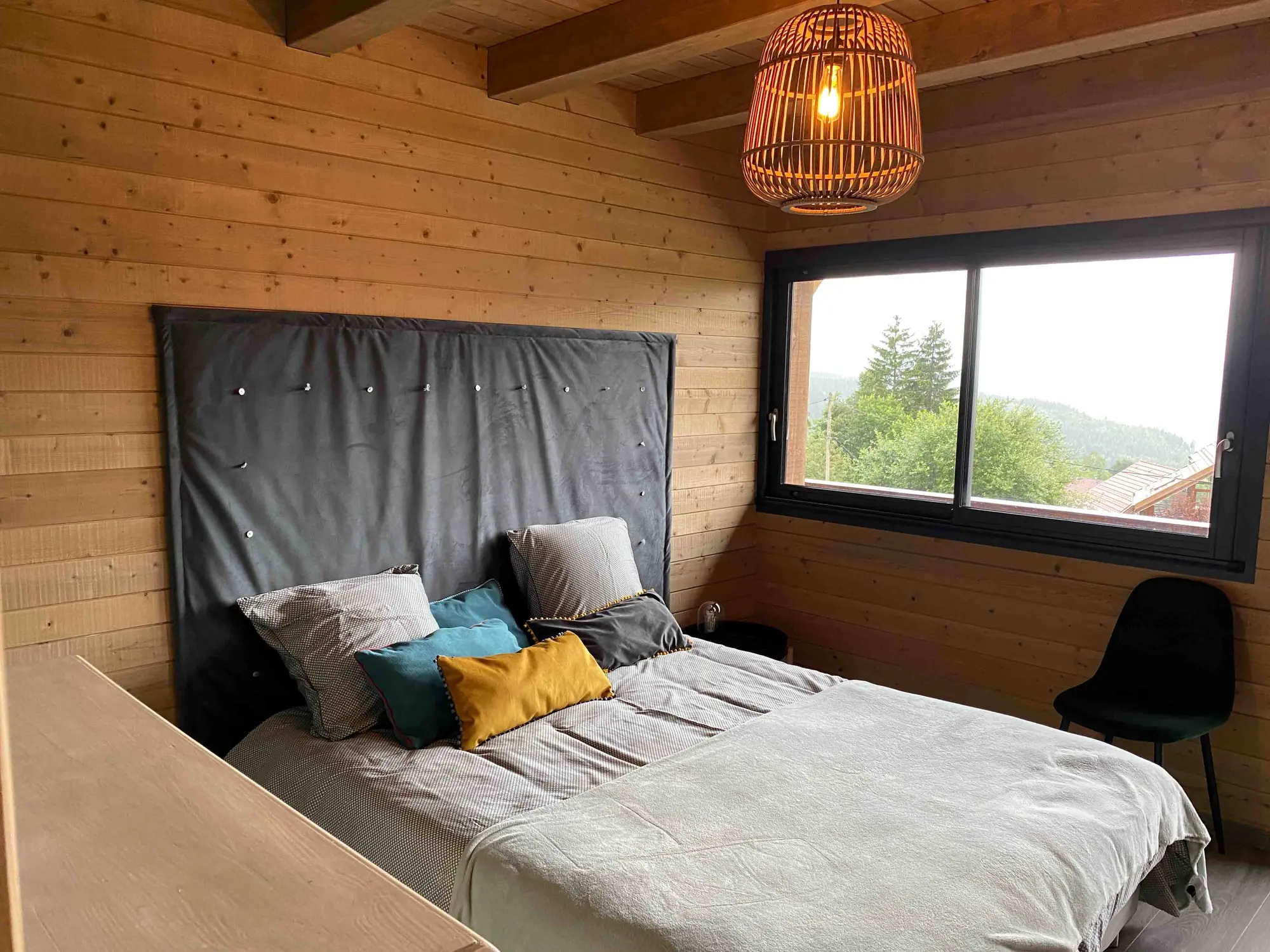 Chambre verte du chalet avec lit double et vue sur les Vosges