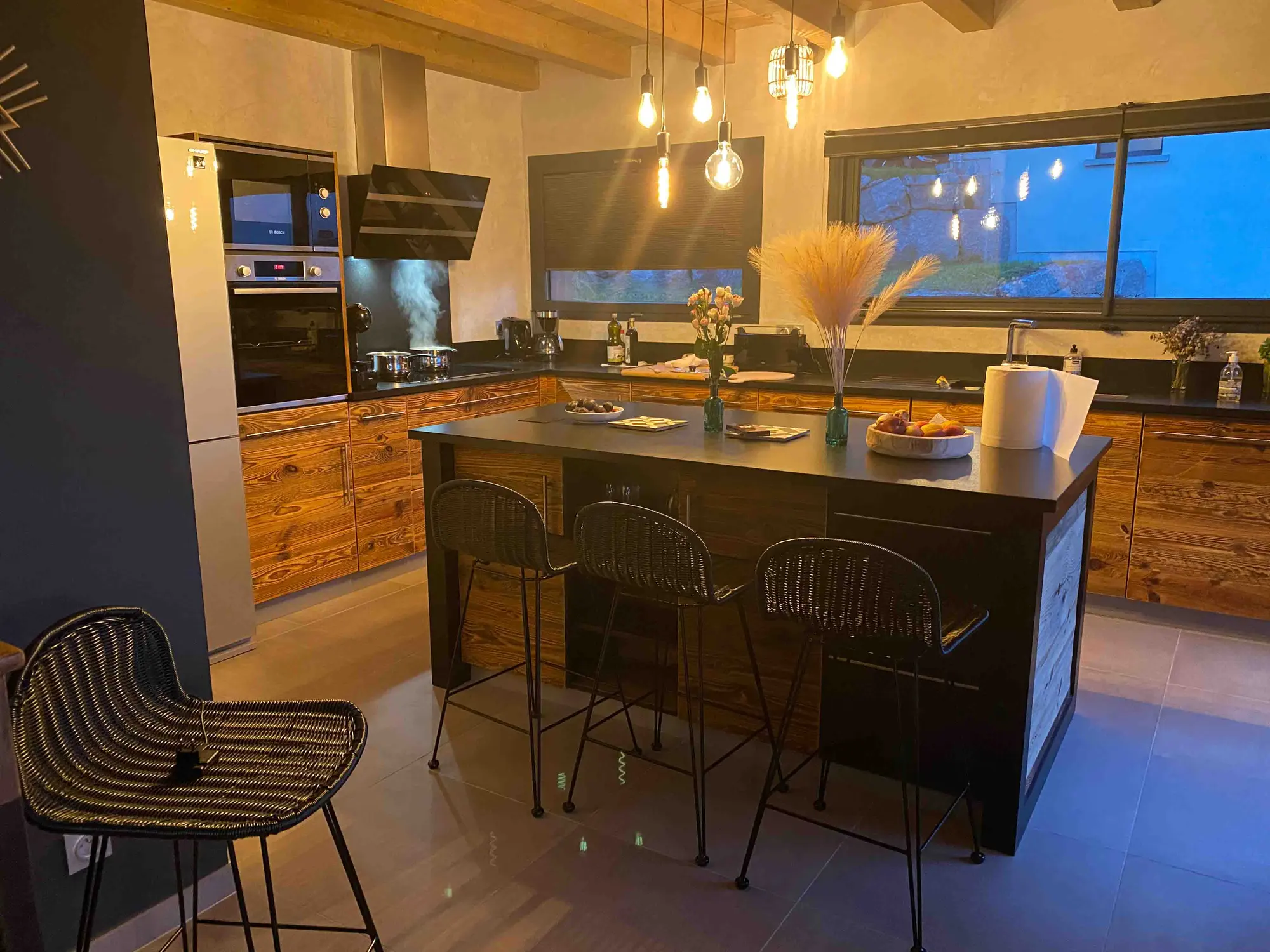 Cuisine ouverte du chalet avec îlot central et vue sur la vallée