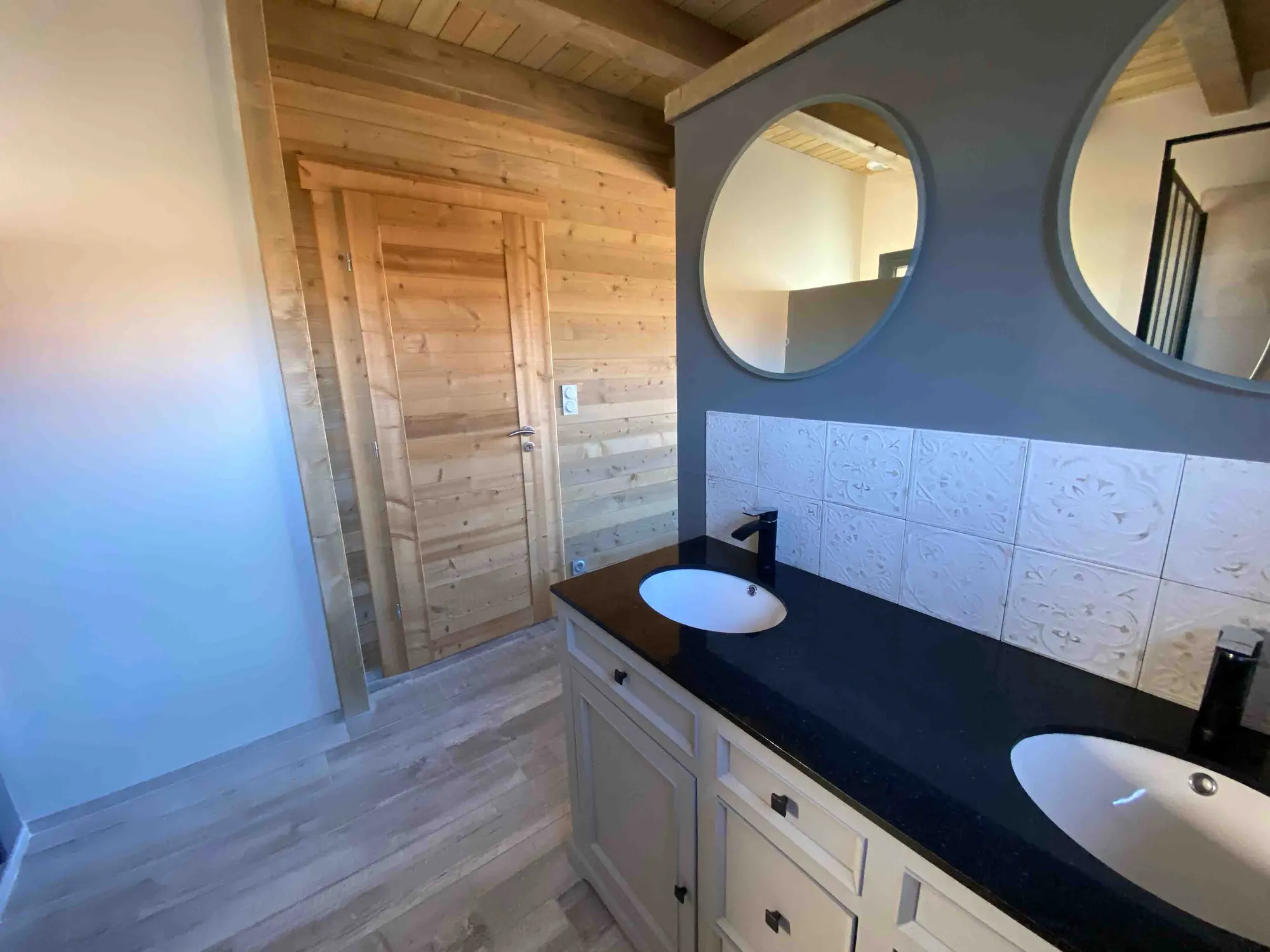 Chalet bathroom with double basins and round mirrors