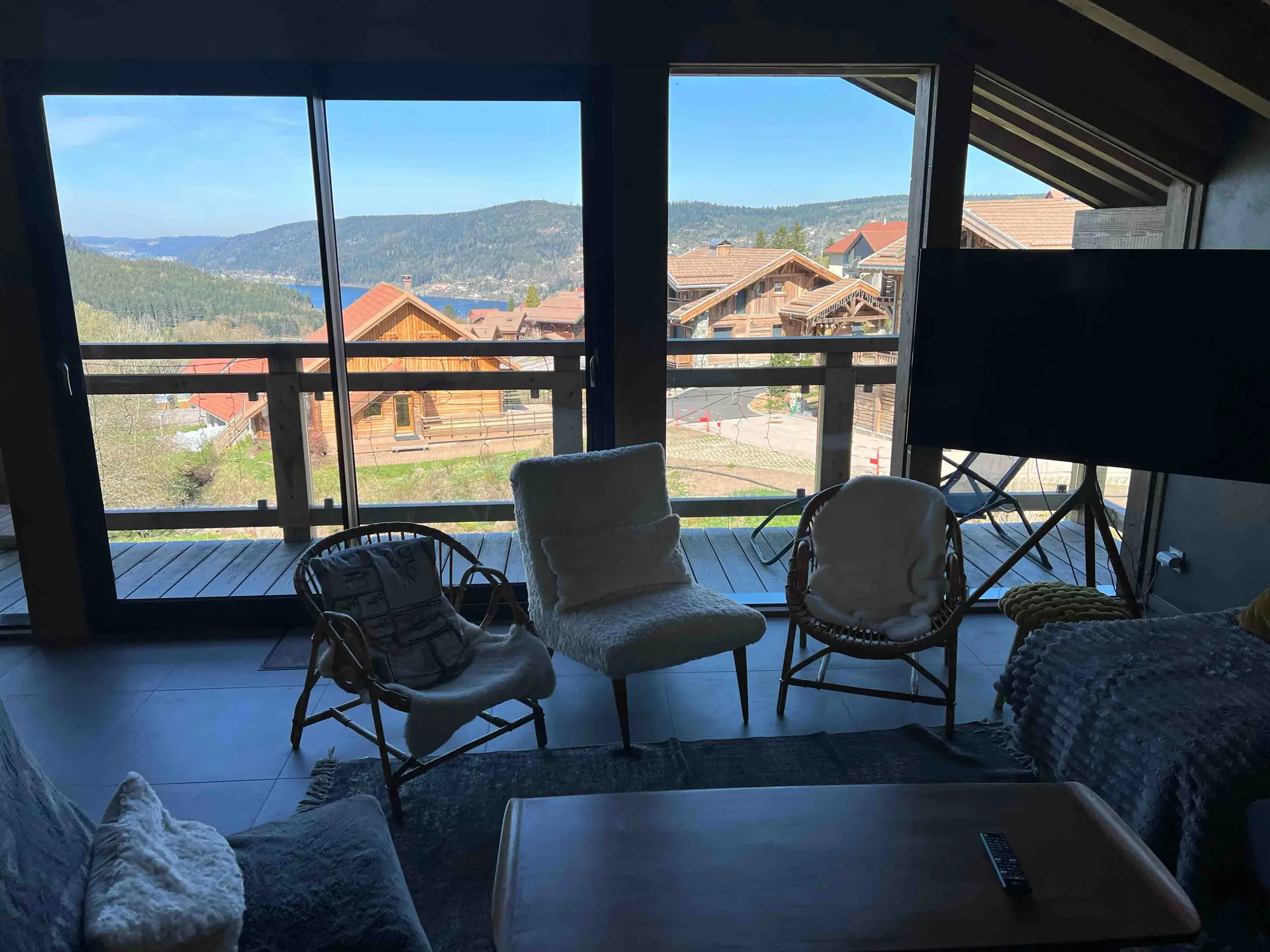 Chalet living room opening onto full-height windows and the lake view
