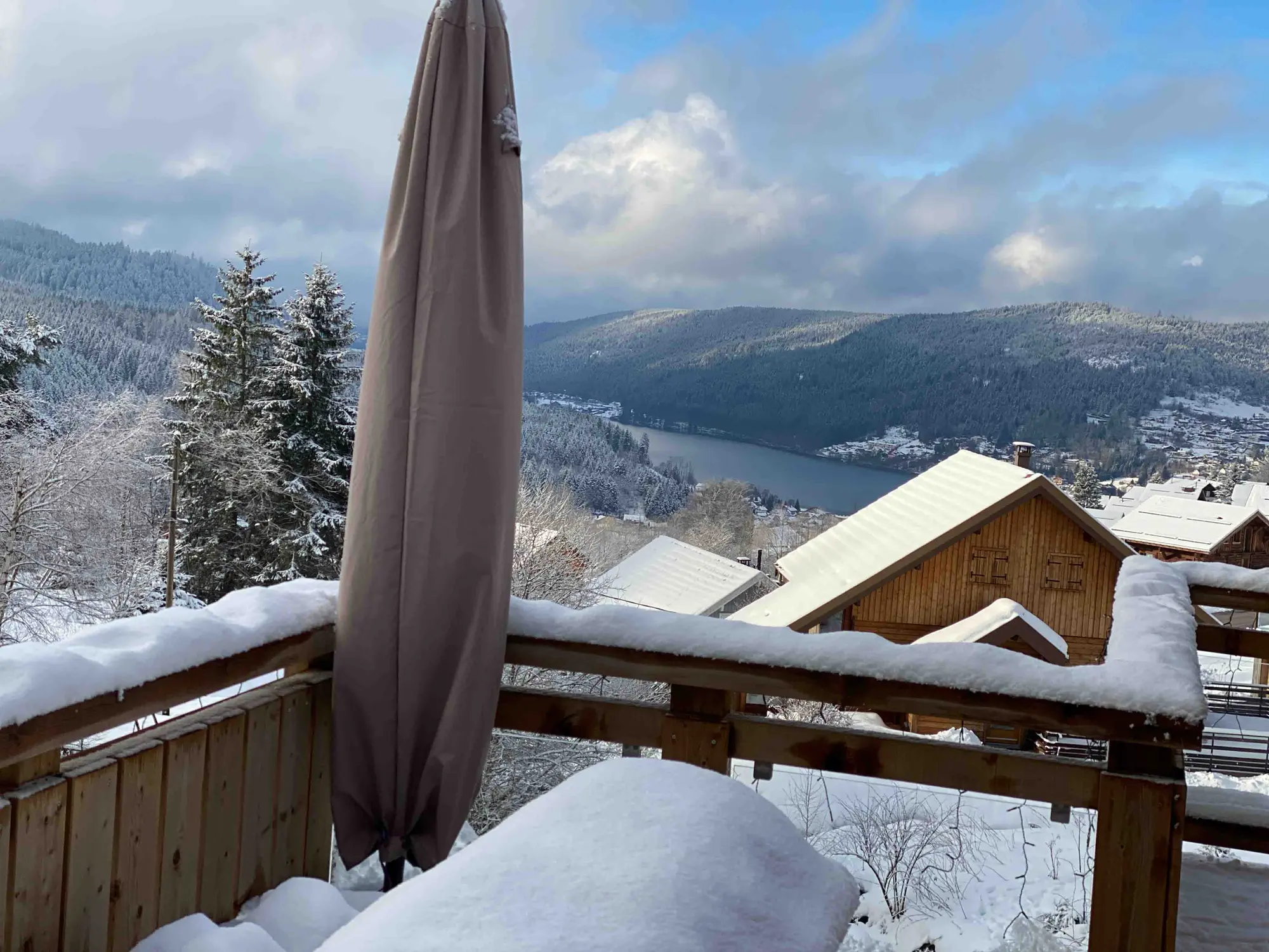 Terrasse enneigée du chalet avec vue sur les montagnes vosgiennes